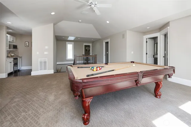 a room with pool table and windows
