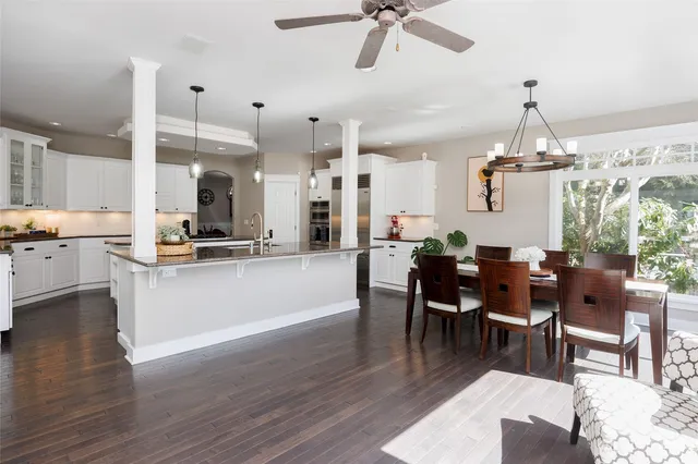 a living room with furniture kitchen view and a chandelier