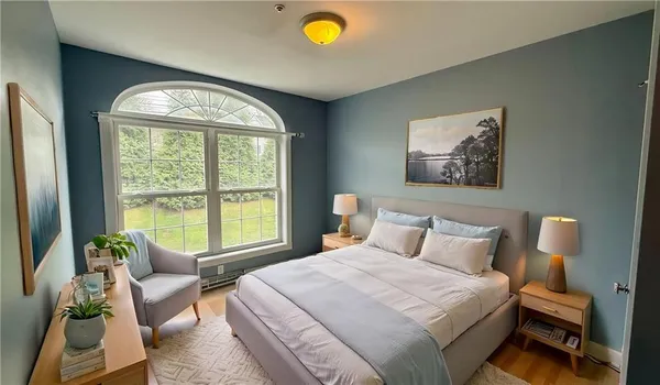 a bedroom with a bed and a large window