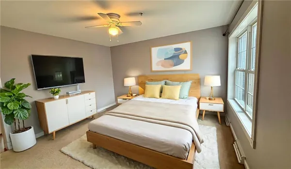 an empty room with a window and a fan