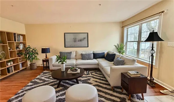 a living room with furniture a table and a large window