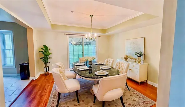 a dining room with furniture a chandelier and wooden floor