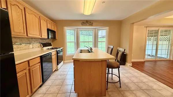a kitchen with a table chairs sink and cabinets