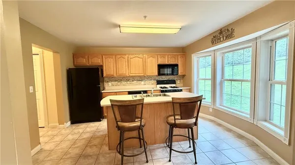 a kitchen with a stove a refrigerator and a microwave