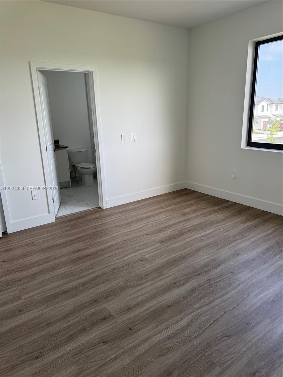 19115 Southwest 344th Terrace Homestead, FL 33034 - Photo 5 of 7 an empty room with wooden floor and a window