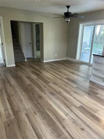 en empty room with wooden floor and windows