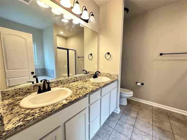 a bathroom with a granite countertop sink a toilet and a mirror
