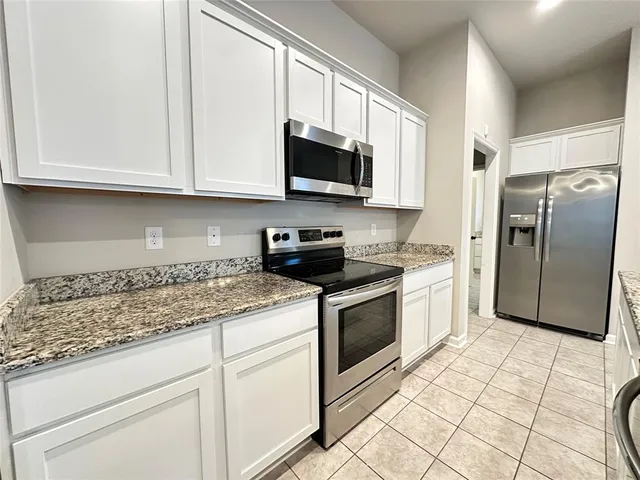 a kitchen with stainless steel appliances granite countertop a sink a stove a microwave and cabinets
