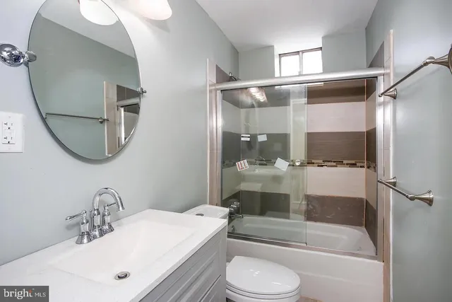 a bathroom with a bathtub shower sink vanity and toilet