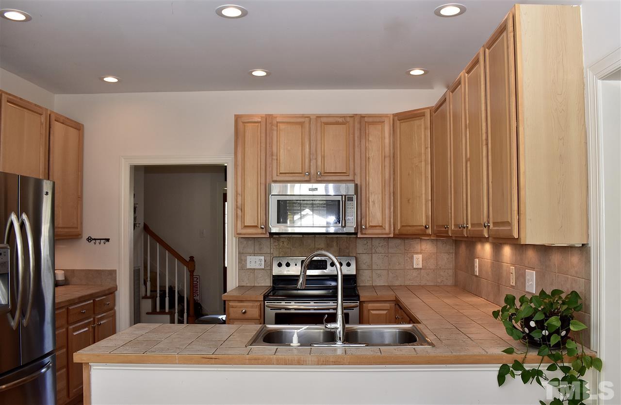545 Lake Glad Road Wendell, NC 27591 - Photo 7 of 25 The kitchen boasts beautiful cabinetry, under-cabinet lighting, and tile backsplash and countertops.