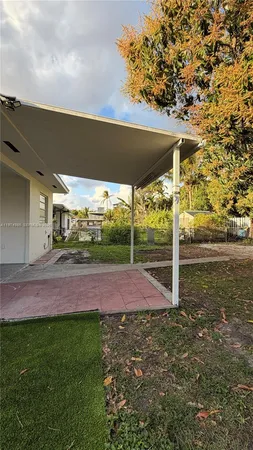 a view of a big yard with plants and large trees