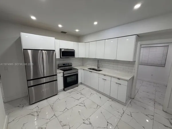 a kitchen with stainless steel appliances a refrigerator and a stove top oven