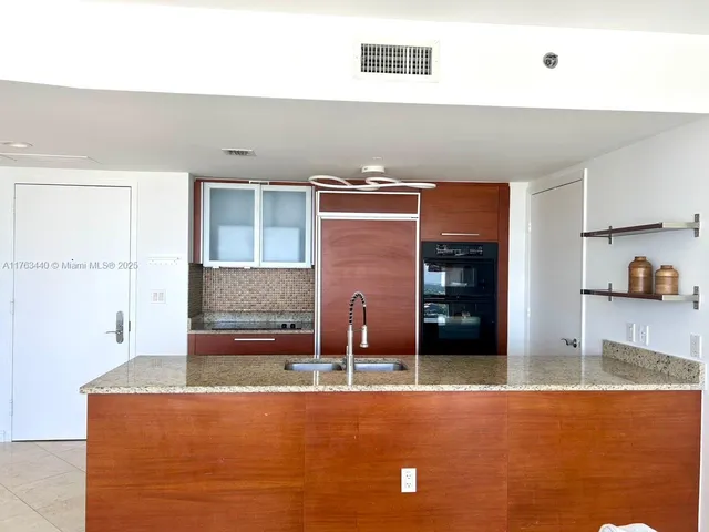 a kitchen with stainless steel appliances granite countertop a refrigerator and a stove