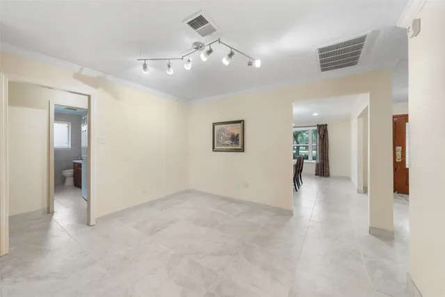 an empty room with wooden floor and hallway