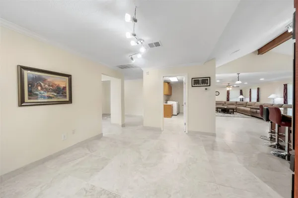 a view of an empty room and a kitchen