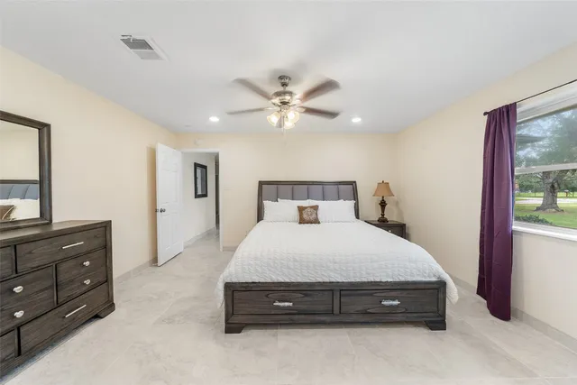 a spacious bedroom with a bed and a dresser