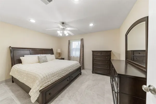 a bedroom with a bed and dresser with mirror