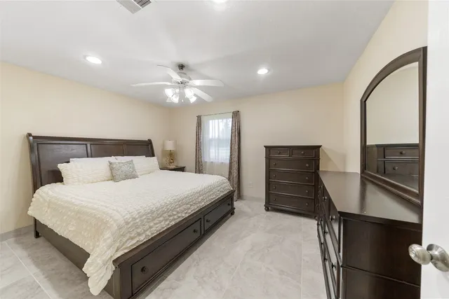 a bedroom with a bed and dresser with mirror