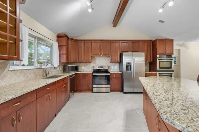 a kitchen with granite countertop a refrigerator and a sink