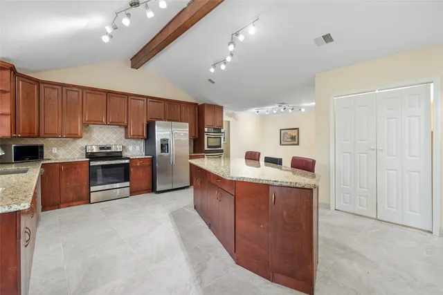 a kitchen with stainless steel appliances granite countertop a refrigerator and stove