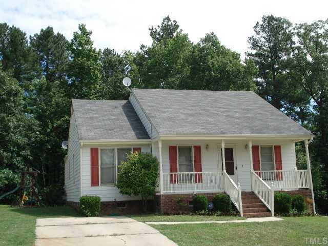 a front view of a house with a yard garden and outdoor seating