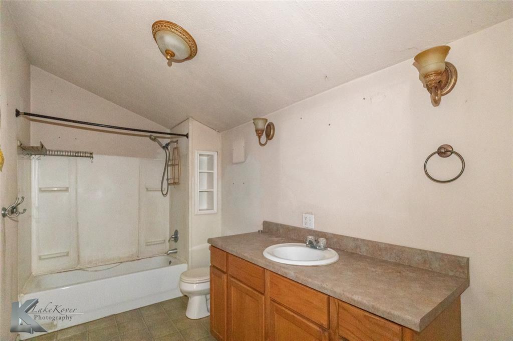 141 East 3rd Street Baird, TX 79504 - Photo 19 of 33 a bathroom with a granite countertop sink toilet and shower