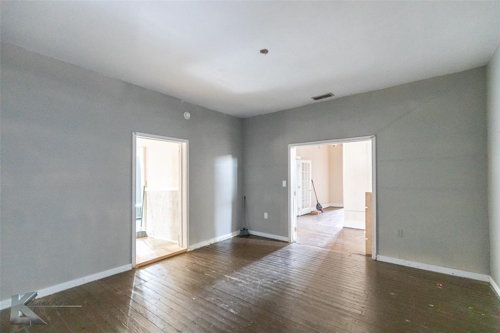 141 East 3rd Street Baird, TX 79504 - Photo 20 of 33 a view of an empty room with wooden floor and a window