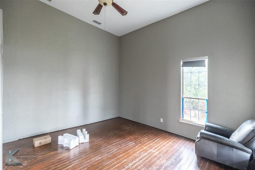 141 East 3rd Street Baird, TX 79504 - Photo 6 of 33 a view of an empty room with wooden floor and a window