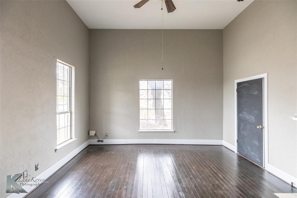 141 East 3rd Street Baird, TX 79504 - Photo 8 of 33 an empty room with wooden floor and windows