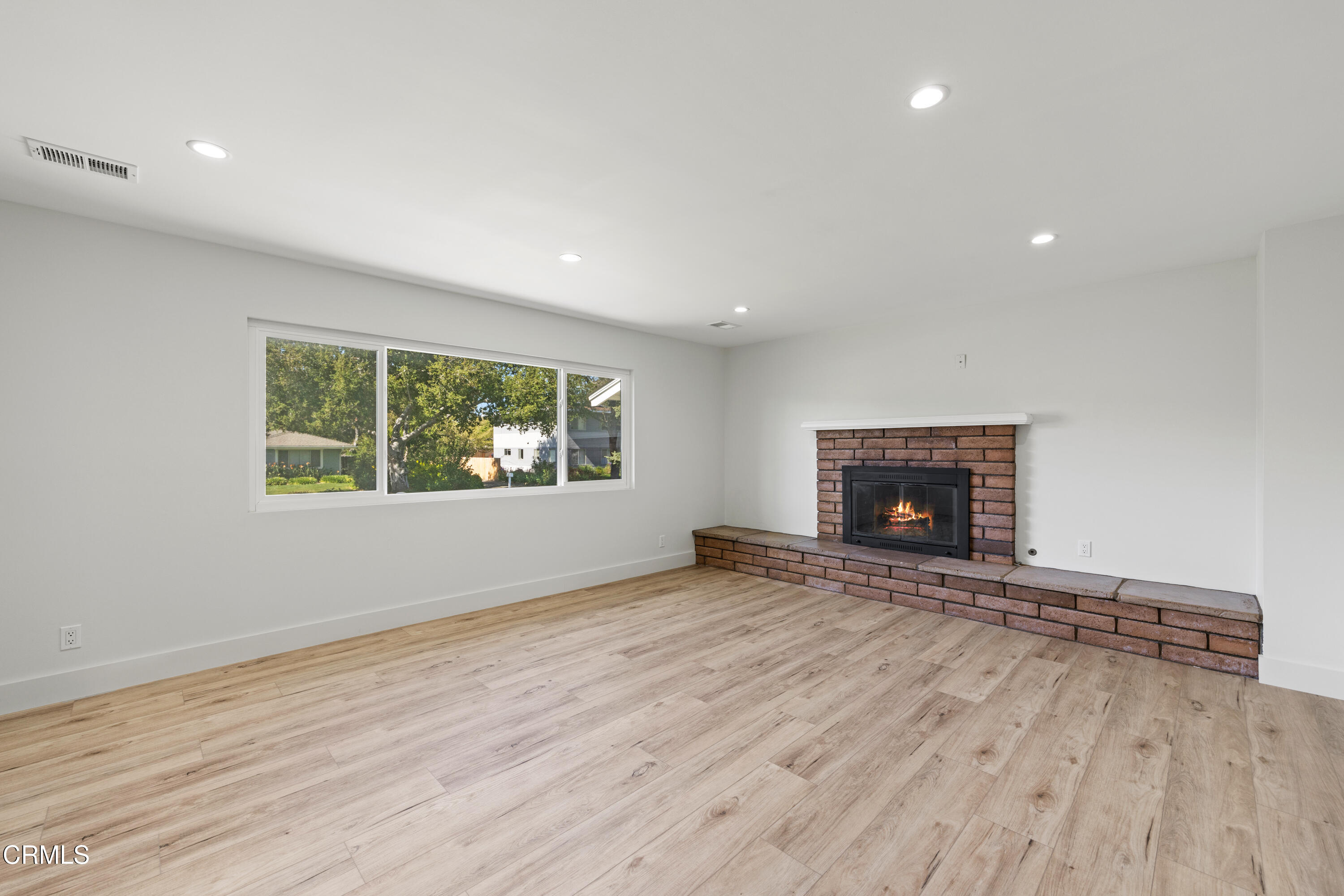 246 3rd Street Solvang, CA 93463 - Photo 6 of 33 an empty room with wooden floor fireplace and windows