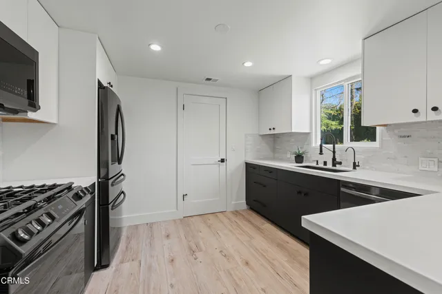 a kitchen with a sink stove top oven and refrigerator