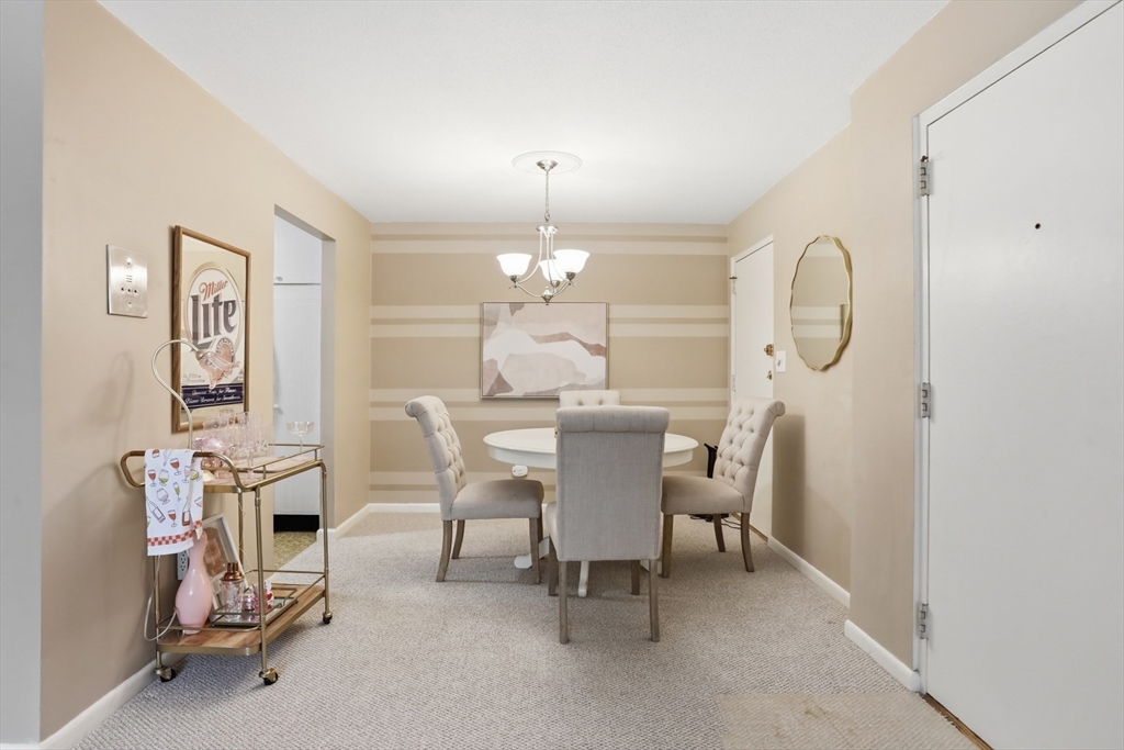 1 Colonial Drive, Unit B1 Andover, MA 01810 - Photo 5 of 14 a dining room with furniture and a chandelier