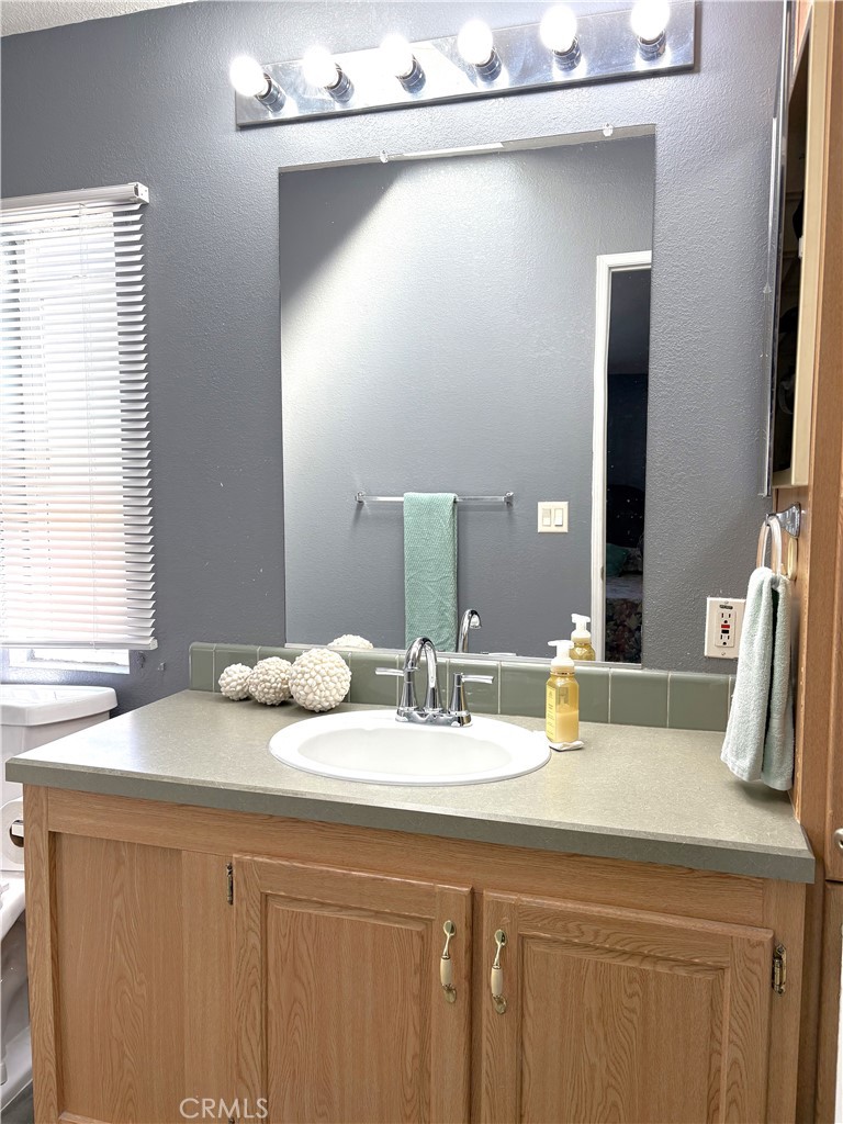 10745 Victoria Avenue, Unit 4 Whittier, CA 90604 - Photo 14 of 16 a bathroom with a granite countertop sink and a mirror