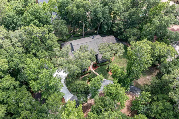 a view of a house with a big yard plants and large trees