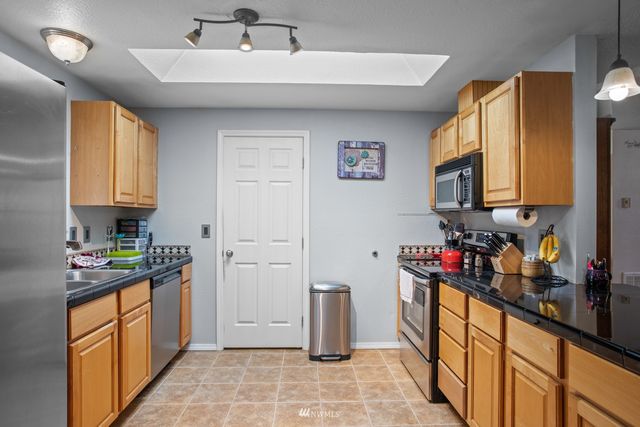 a kitchen with stainless steel appliances granite countertop a sink stove and cabinets