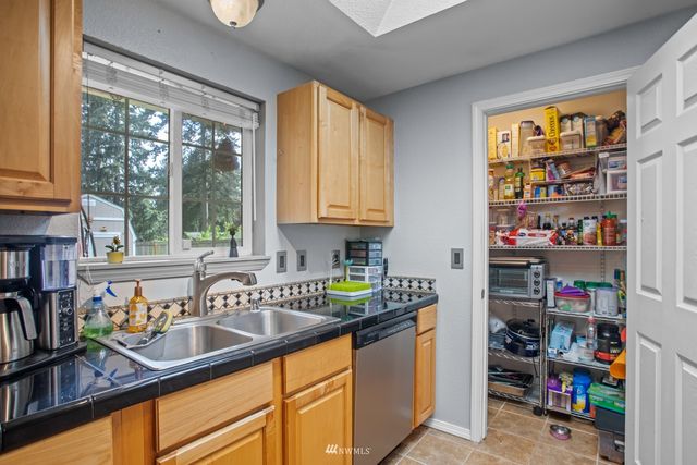 a kitchen with granite countertop a sink dishwasher and a refrigerator with wooden floor