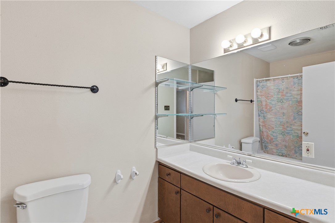 102 Runnel Street Seguin, TX 78155 - Photo 19 of 34 a bathroom with a granite countertop sink a toilet and shower