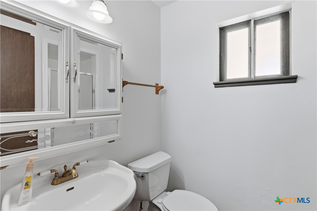 102 Runnel Street Seguin, TX 78155 - Photo 21 of 34 a bathroom with a sink mirror and toilet