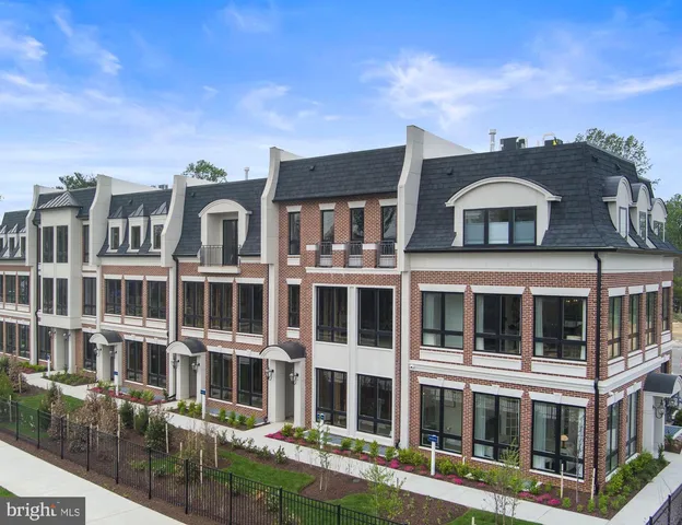 a front view of a residential apartment building with a yard