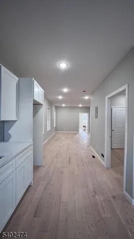 a view of a big room with wooden floor and windows