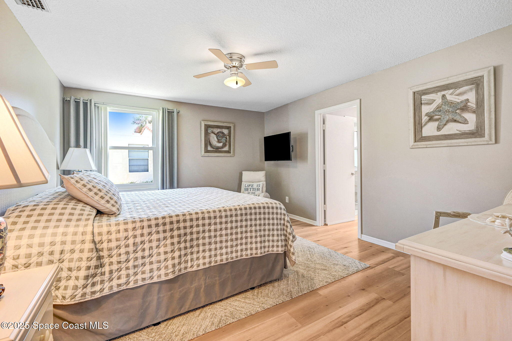 730 Spring Valley Drive Melbourne, FL 32940 - Photo 16 of 39 a bedroom with a large bed and a chandelier