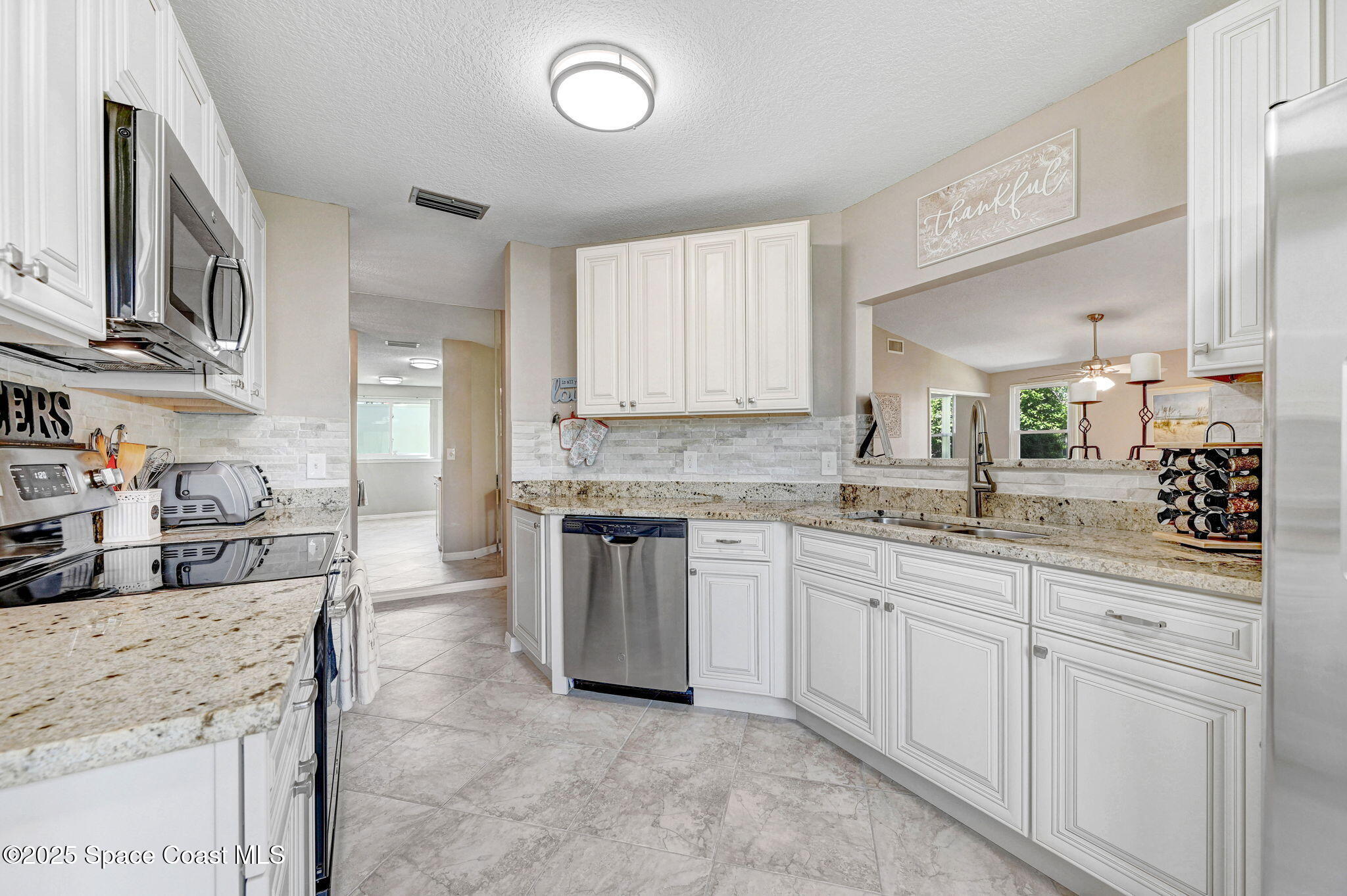 730 Spring Valley Drive Melbourne, FL 32940 - Photo 23 of 39 a kitchen with granite countertop a sink stove and cabinets