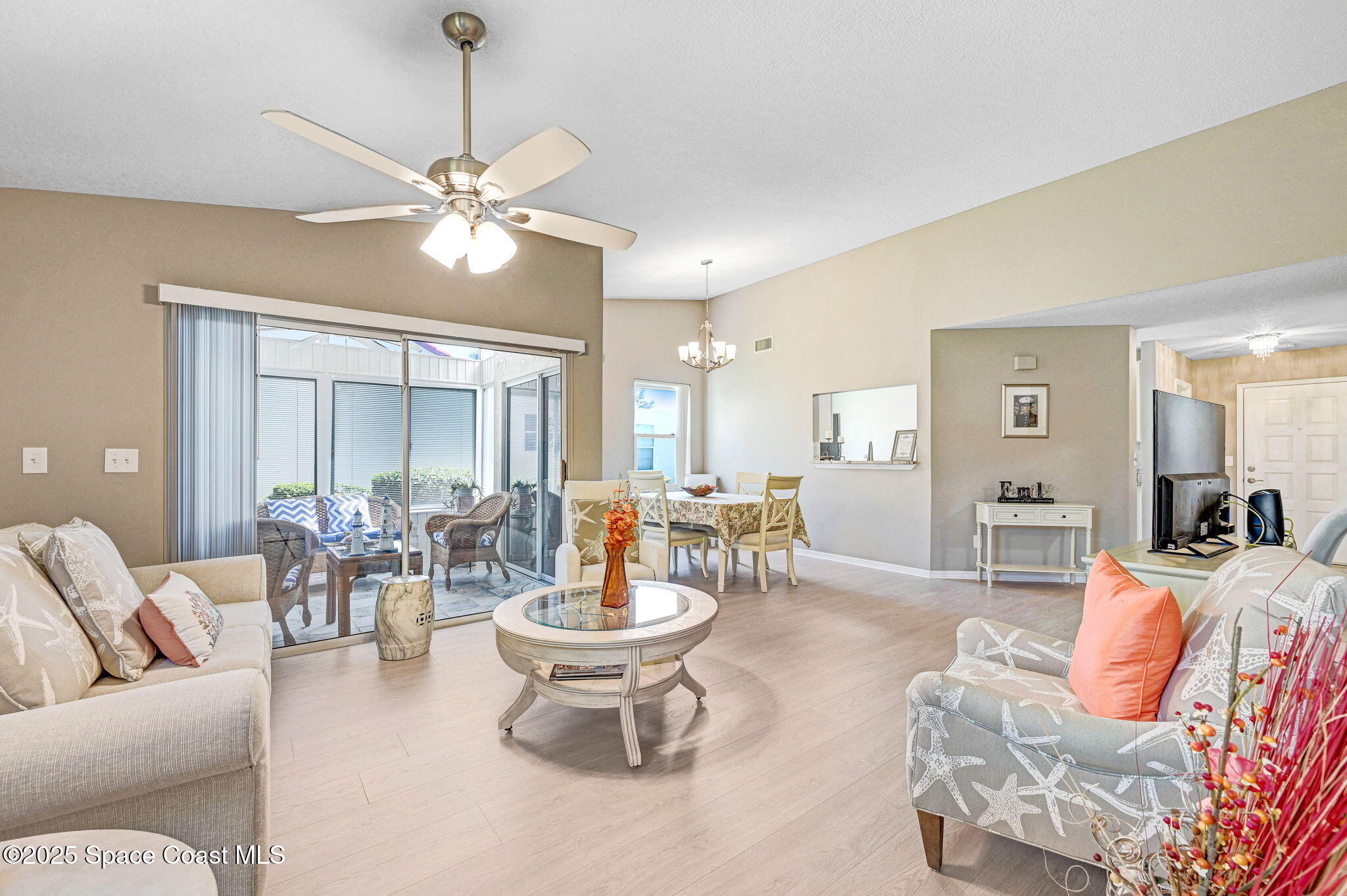 730 Spring Valley Drive Melbourne, FL 32940 - Photo 30 of 39 a living room with furniture a chandelier and a dining room