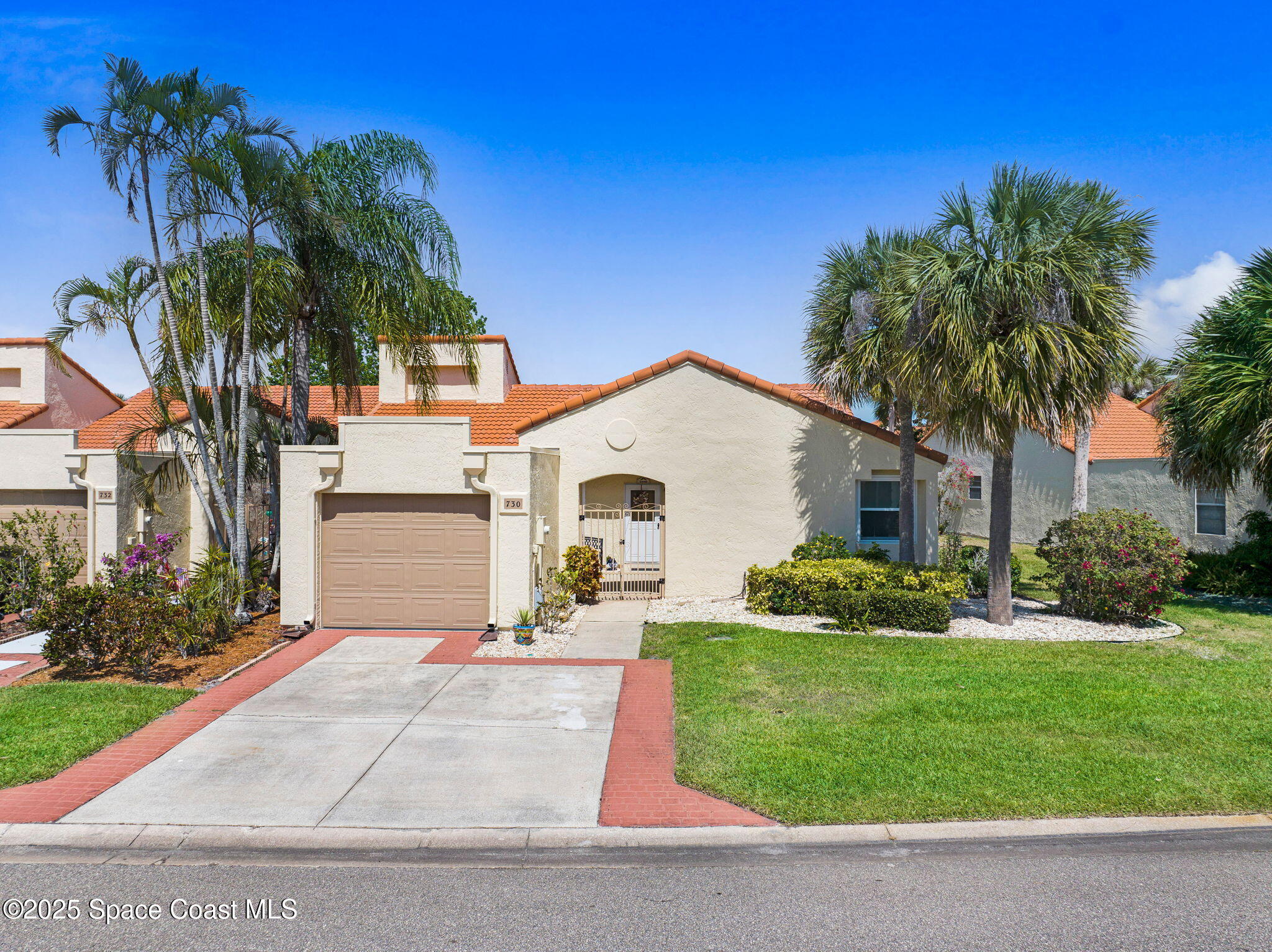 730 Spring Valley Drive Melbourne, FL 32940 - Photo 7 of 39 a front view of a house with a garden and palm trees