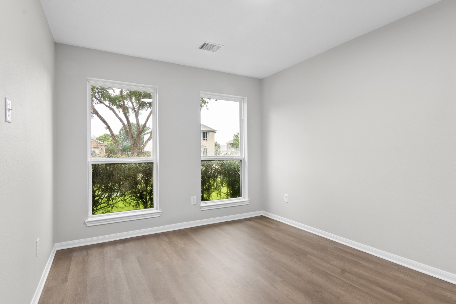 7811 Adonis Avenue Baytown, TX 77521 - Photo 21 of 36 an empty room with wooden floor and windows