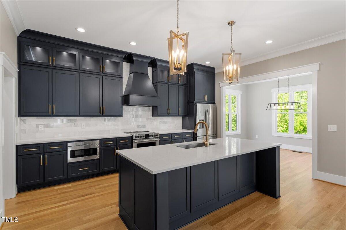 3934 Old Chapel Hill Road Durham, NC 27707 - Photo 19 of 47 a kitchen with stainless steel appliances a sink dishwasher a stove a refrigerator and a oven with wooden floor