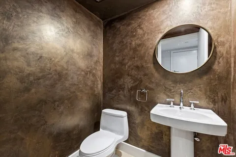 a bathroom with a toilet a sink and mirror