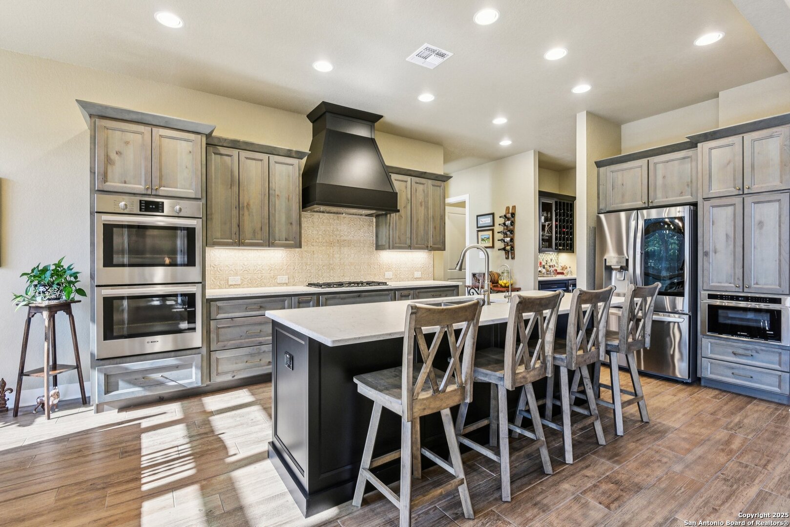 449 Hanging Oak Spring Branch, TX 78070 - Photo 16 of 49 a kitchen with stainless steel appliances kitchen island granite countertop a stove a refrigerator a sink a dining table and chairs with wooden floor