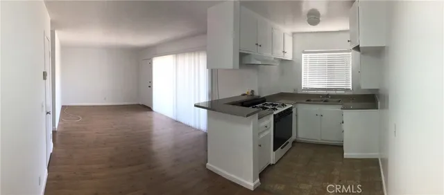 a kitchen with granite countertop a sink stove and cabinets