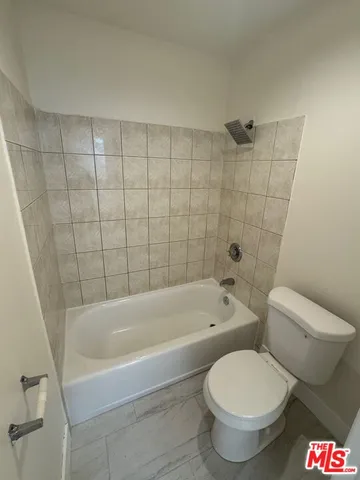 a white toilet sitting next to a bath tub
